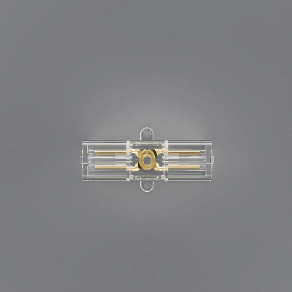 A clear plastic rectangular component with gold-colored internal rods and a circular gold center, shown against a solid gray background.
